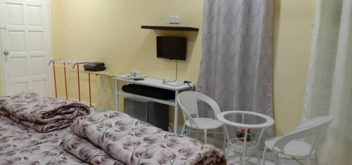a bedroom with a bed and a desk and chairs at Jeli Heights Hill Homes in Jeli