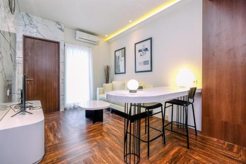a living room with a table and a couch at Good Deal 2BR at High Floor Transpark Cibubur Apartment By Travelio in Depok