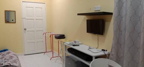 a room with a bed and a table with a television at Jeli Heights Hill Homes in Jeli