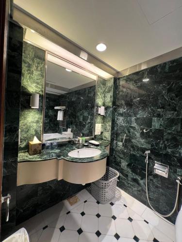 a bathroom with a sink and a large mirror at Orchard Point Serviced Apartments in Singapore
