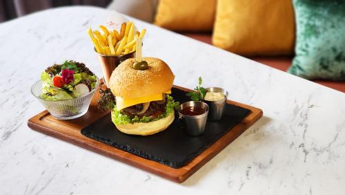 a sandwich and french fries on a tray on a table at Imperial Lexis Kuala Lumpur in Kuala Lumpur