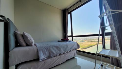 a room with a couch with a large window at Palam Mansion at Apartment One Residence in Batam Center