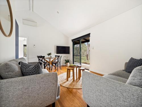 a living room with two couches and a table at Island Brook Estate Vineyard and Chalets in Yelverton