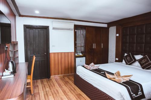 a bedroom with a large bed and a desk at Vientiane Garden Villa Hotel And Coffee in Vientiane
