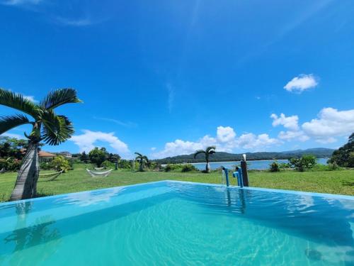 a swimming pool with a view of the water at Villa Unarizaki in Iriomote
