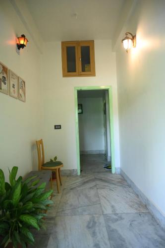 a room with a hallway with a table and a door at Axom Aura in Tezpur