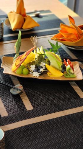 a plate of food with fruits and vegetables on a table at Imperial Lexis Kuala Lumpur in Kuala Lumpur