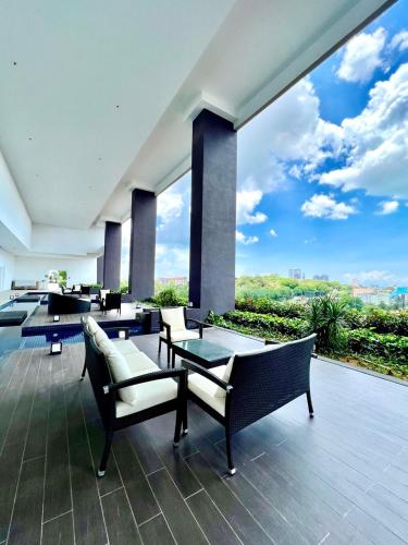 a patio with chairs and tables and a large window at Courtyard by Marriott Melaka in Melaka