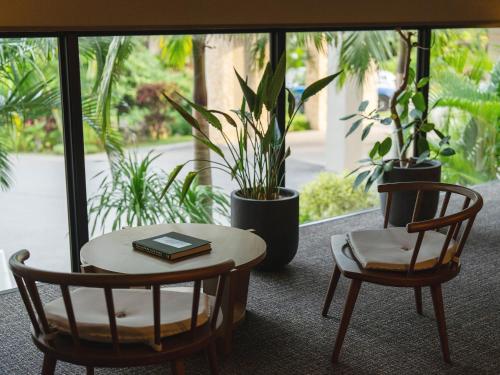 a table and two chairs and a book on a table at Glamday Style Okinawa Yomitan Hotel & Resort in Yomitan
