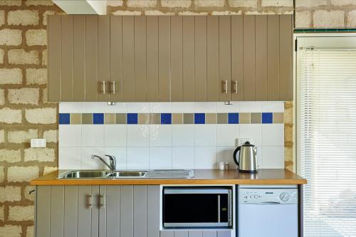 a kitchen with a sink and a microwave at Seahaven Village in Barwon Heads
