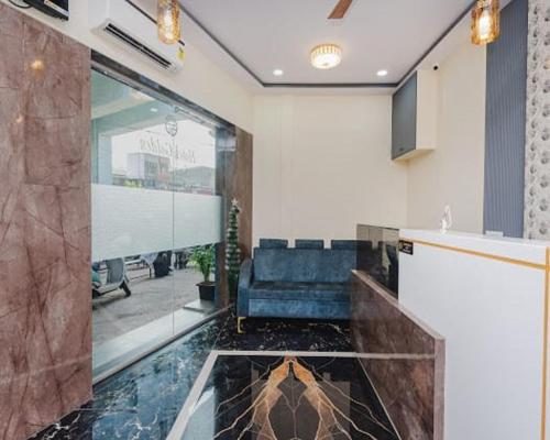 a lobby with a couch and a large glass window at Hotel Golden Sands Inn Aslpha in Mumbai