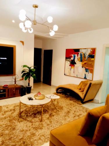 a living room with a couch and a table at Professionals Friendly with Work Station PS5 & near Beaches in Lekki