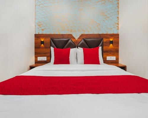 a bedroom with a large bed with red pillows at Hotel Golden Sands Inn Aslpha in Mumbai