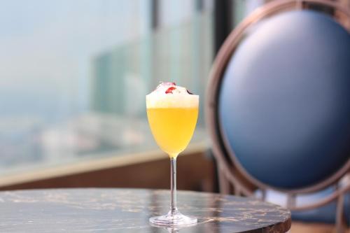 a drink in a glass sitting on a table at Imperial Lexis Kuala Lumpur in Kuala Lumpur