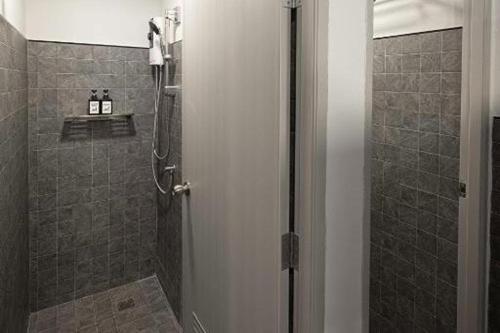 a bathroom with a shower with a glass door at Ed Hostel Rachamakka in Chiang Mai