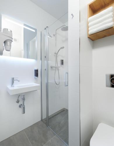 a bathroom with a shower and a sink at Wellness Hotel Svornost in Harrachov