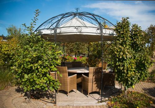 a table and chairs under an umbrella in a garden at Best Western Hotel am Walserberg in Wals