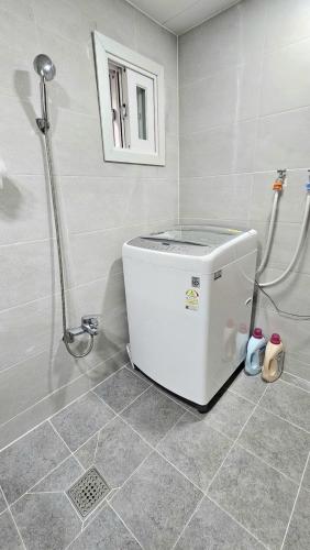 a small refrigerator in a bathroom with a shower at Byulchae Guest House - Foreigner Only in Seoul