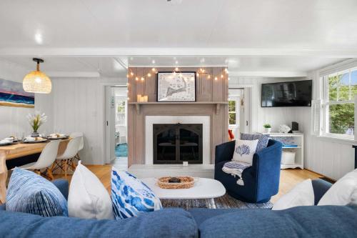 a living room with a blue couch and a fireplace at Short Walk to Private Association Beach in Eastham