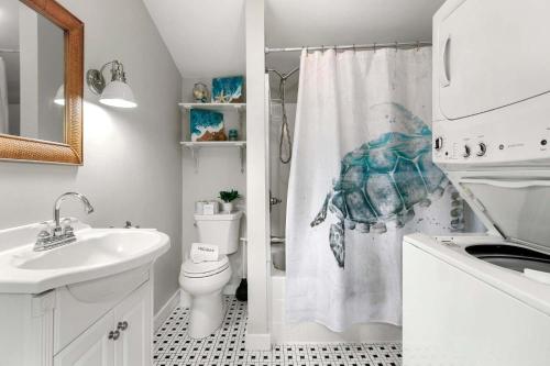 a bathroom with a toilet and a shower curtain at Short Walk to Private Association Beach in Eastham