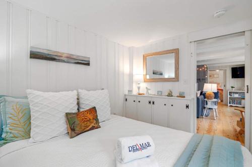 a bedroom with a large white bed with a mirror at Short Walk to Private Association Beach in Eastham