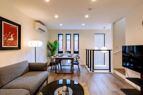 a living room with a couch and a table at JS暁宅-東雲 shinonome in Osaka