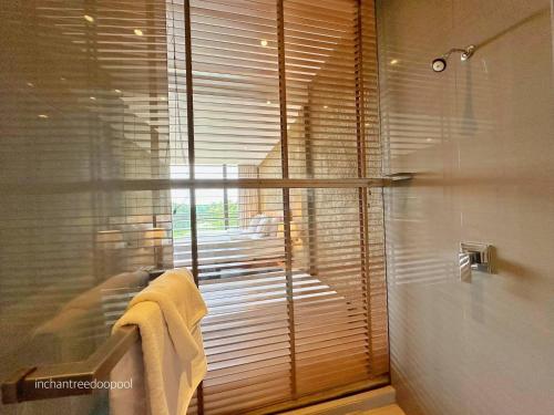 a bathroom with a shower and a window with towels at Inchantreedoopool in Kanchanaburi City