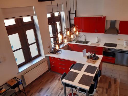a kitchen with red cabinets and a table with chairs at Het Maelslot (Mechelen) in Mechelen