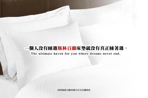 a pile of white pillows on a bed with a sign on it at 168 Motel-Hsinchu in Hsinchu City