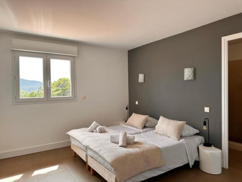 Un dormitorio con una cama grande y una ventana. en ALTO DI PINARELLO, en Sainte-Lucie de Porto-Vecchio