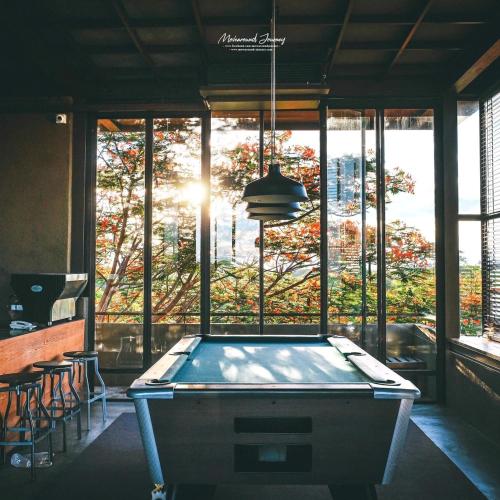 a pool table in front of a large window at Inchantreedoopool in Kanchanaburi