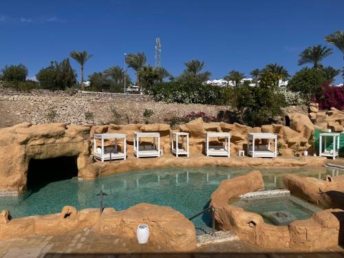 a pool with lounge chairs in a rock formation at Elisir SPA & Hotel at Sheikh coast in Sharm El Sheikh