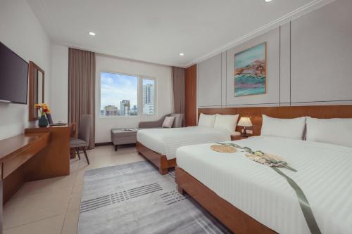 a hotel room with two beds and a television at Star Hotel and Spa Danang in Danang