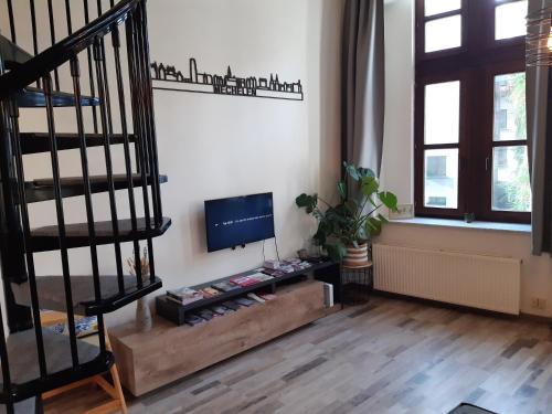 a living room with a staircase and a flat screen tv at Het Maelslot (Mechelen) in Mechelen
