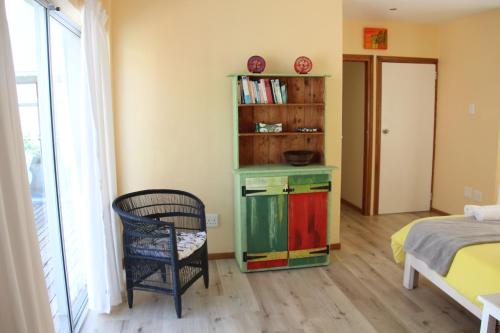 a bedroom with a bed and a book shelf at Ungabona in East London