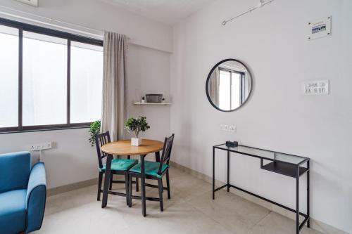 a dining room with a table and chairs and a mirror at Quirky 1BHK Bandra W by The Bombay Home Company in Mumbai
