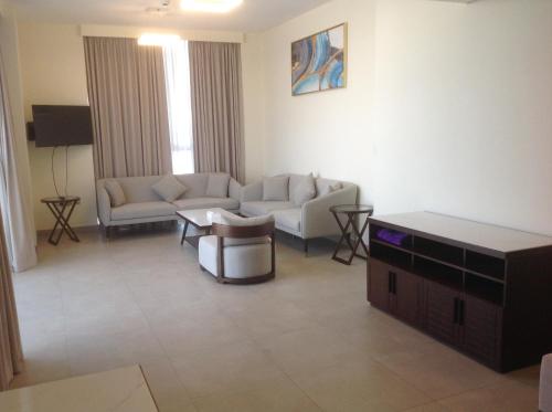 a living room with two couches and a table at Saray Deluxe Hotel Apartments in Abu Dhabi