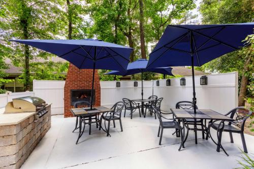 a patio with tables and chairs with umbrellas at Hampton Inn & Suites Tallahassee I-10-Thomasville Road in Tallahassee