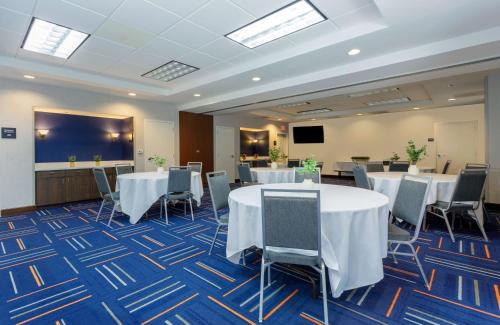 a conference room with tables and chairs and a screen at Hampton Inn & Suites Tallahassee I-10-Thomasville Road in Tallahassee