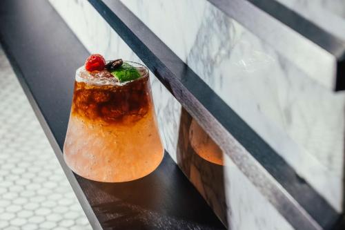 a drink sitting on top of a black rail at Hilton Vienna Plaza in Vienna