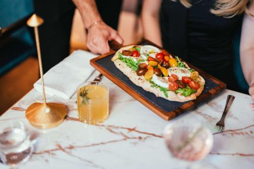 a pizza on a plate on a table at Hilton Vienna Plaza in Vienna
