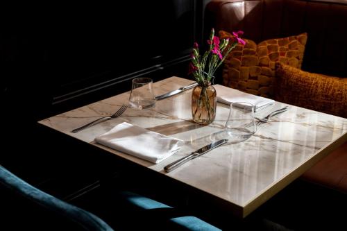 a table with a vase of flowers on top of it at Hilton Vienna Plaza in Vienna