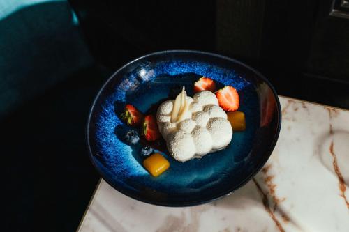 a blue bowl filled with fruit and vegetables on a table at Hilton Vienna Plaza in Vienna