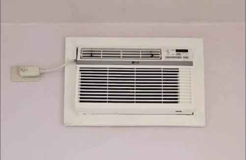 a white air conditioner attached to a wall at Lio Palm Villas in Langi-langiban