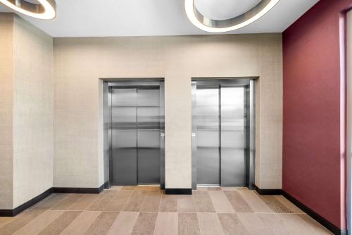 a row of elevators in a building at Tru by Hilton Plano Hwy 75 in Plano