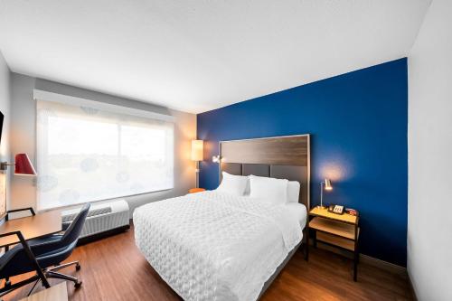 a bedroom with a bed and a desk and a window at Tru by Hilton Plano Hwy 75 in Plano