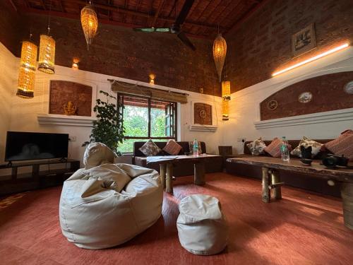 a living room with a couch and a table at Surangi Homestays in Ajgaon