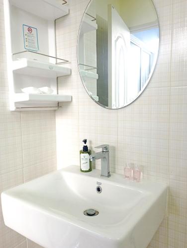 a white sink in a bathroom with a mirror at Bangkok Siam in Bangkok