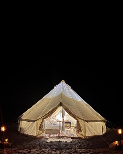 a large white tent with lights in the dark at Thousand Stars Desert Camp in Bidiyah
