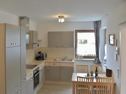 a kitchen with a table and a refrigerator and a sink at Chalet in Fulpmes near Stubai Glacier Skiing in Fulpmes